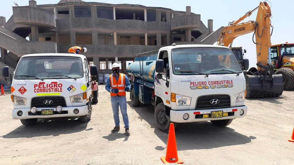 Cisternas de Green Horizonte con señalización de combustible en una obra, junto a maquinaria pesada